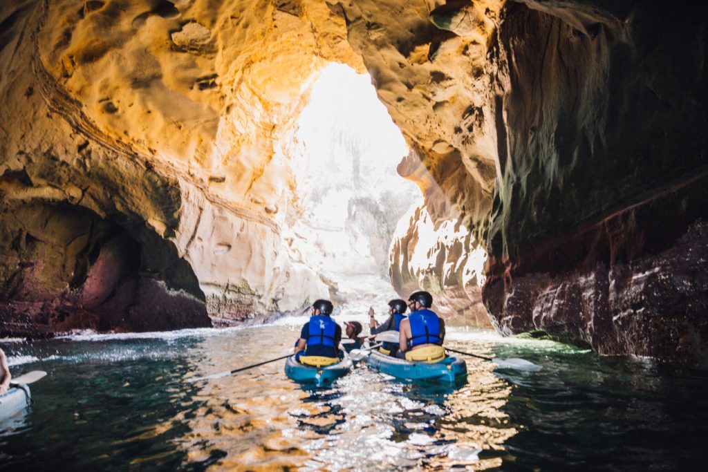 group of people kayaking through a cave