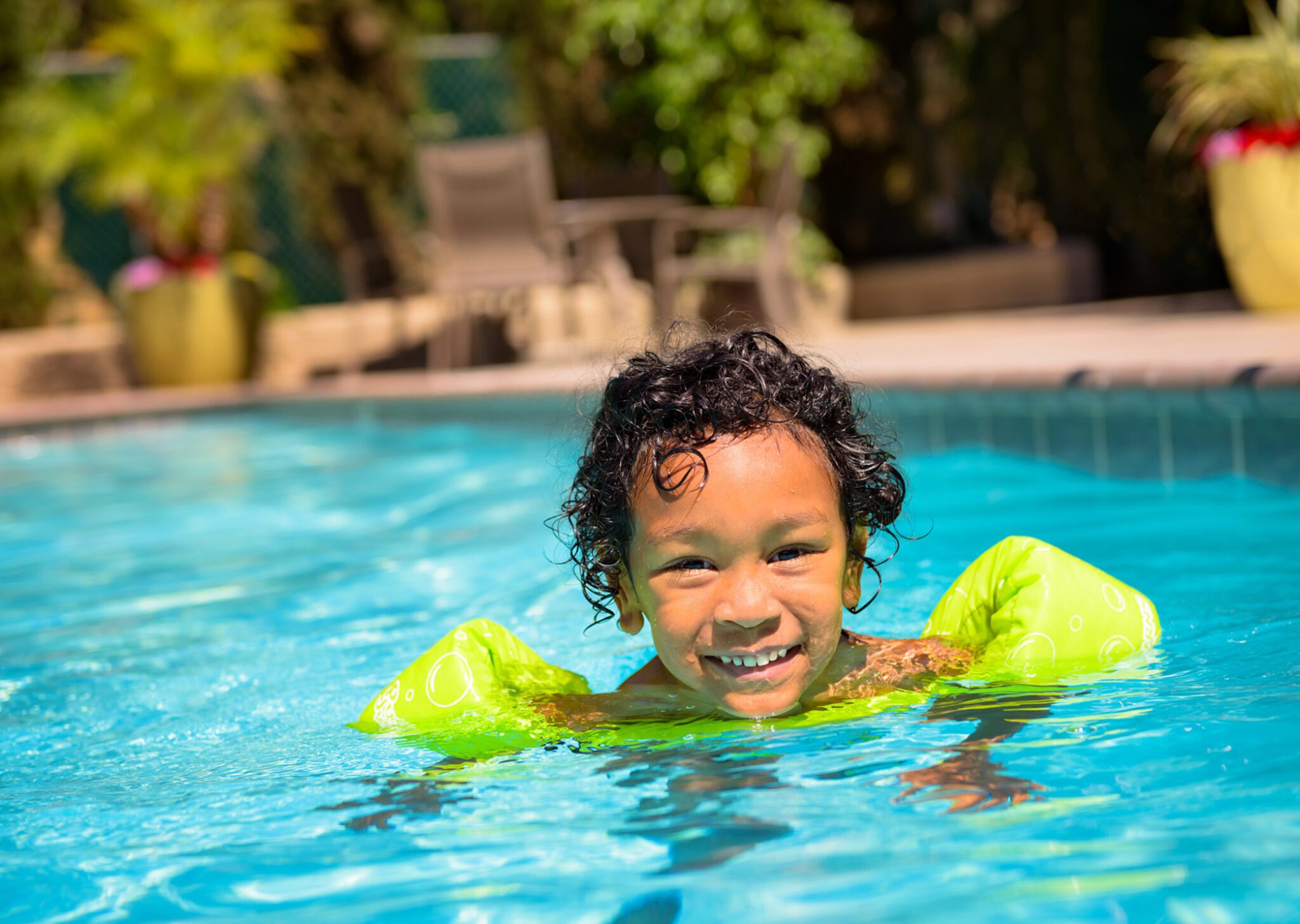 a child in the pool wearing arm floaties