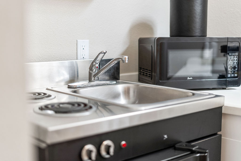 Kitchenette details image of sink, stove and microwave