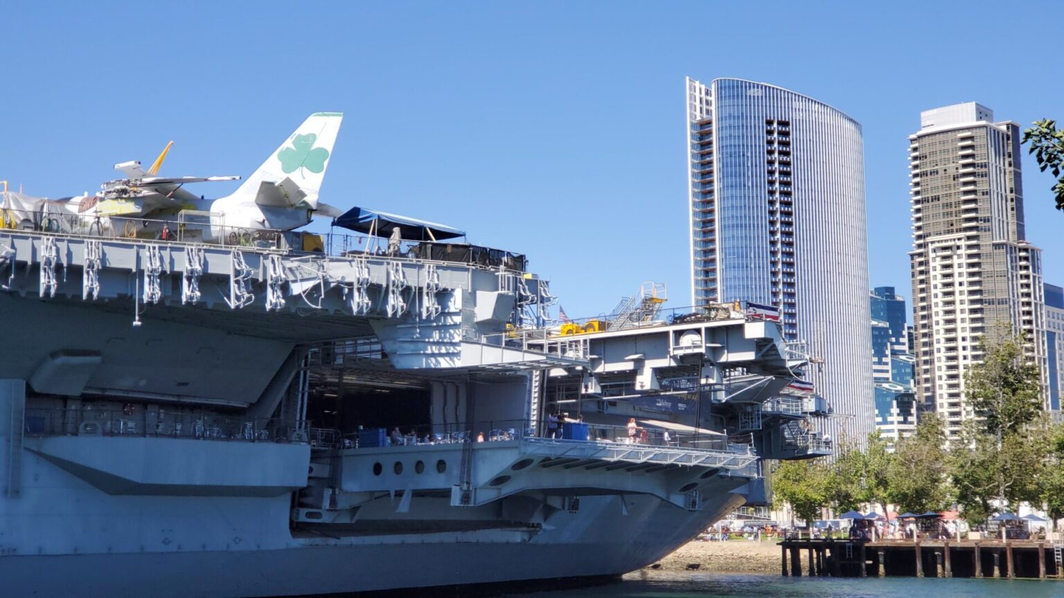 The USS Midway aircraft carrier docked with modern San Diego skyscrapers in the background.