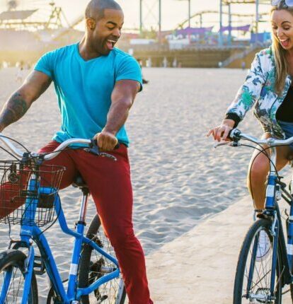 a man and woman goofing off on bicycles
