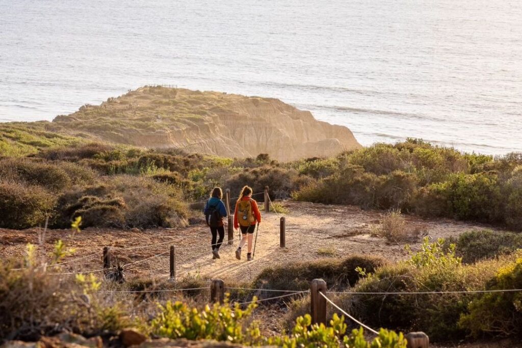 two people hiking on the beach