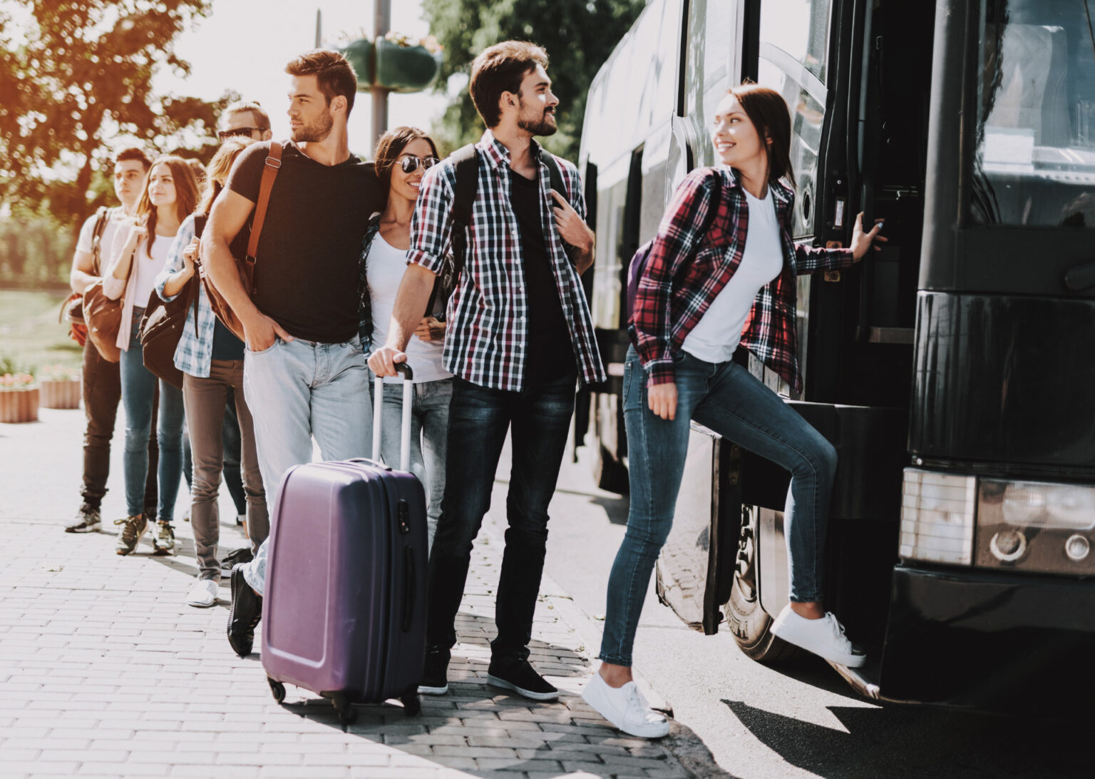 A Group of people lined up to board a bus