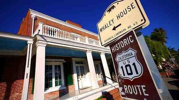 the exterior or a colonial style brick building with large white columns and a sign that says Whaley House
