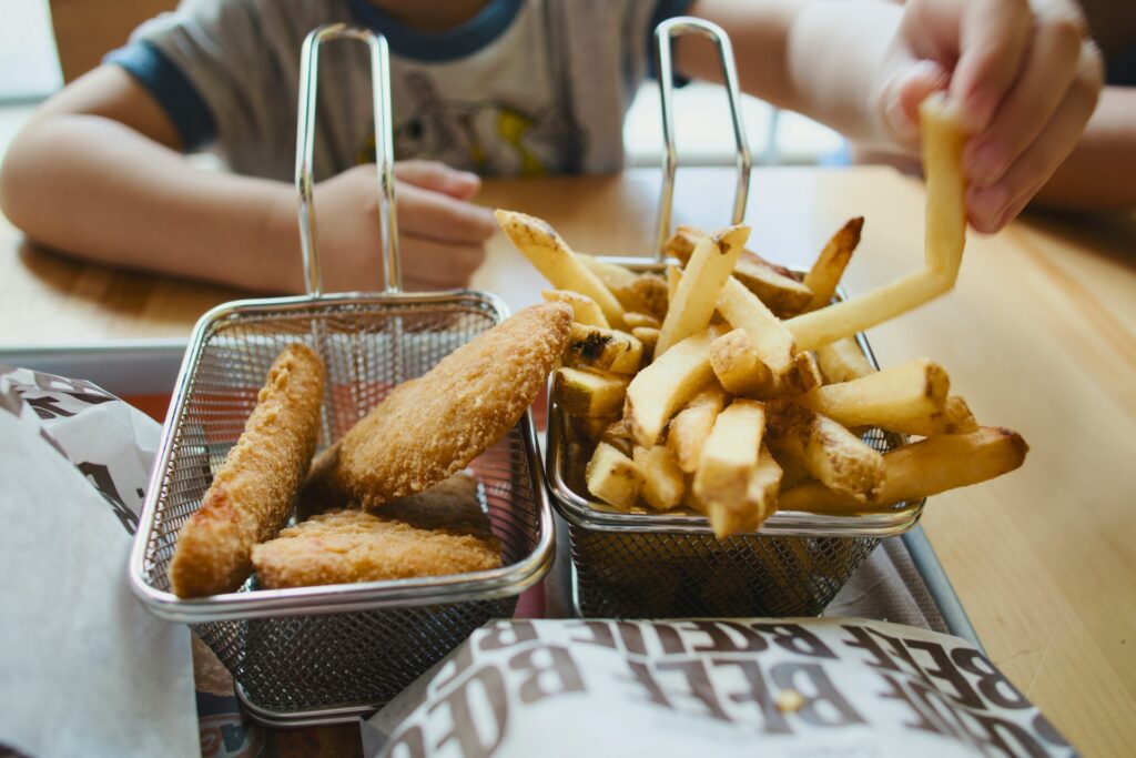 kid eating chicken and fries