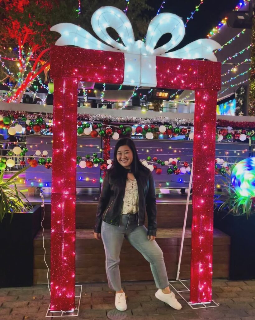 girl standing in front of holiday decorations