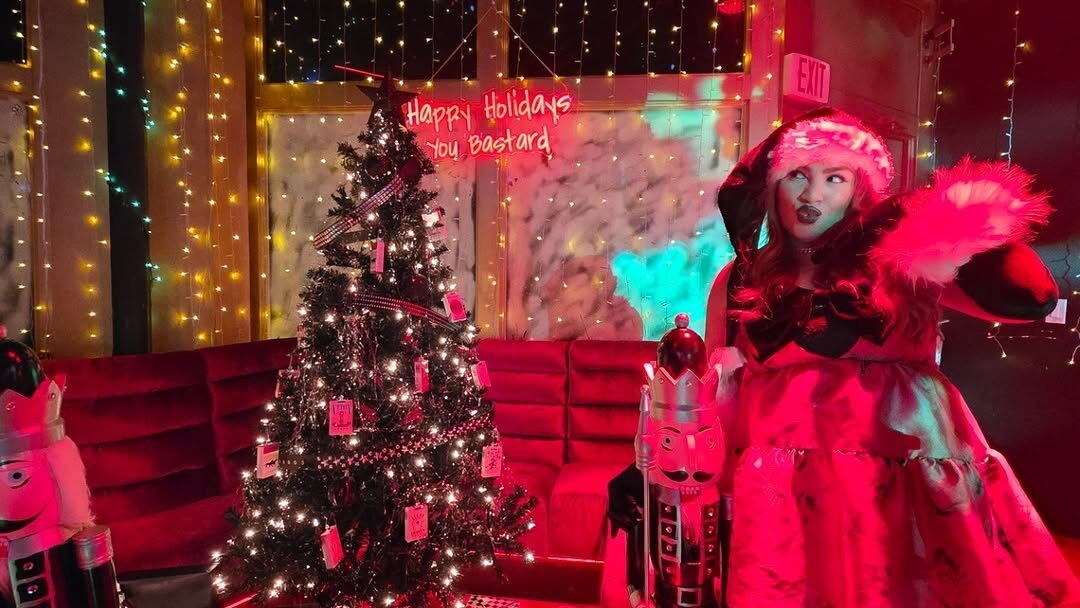 girl standing next to Christmas tree