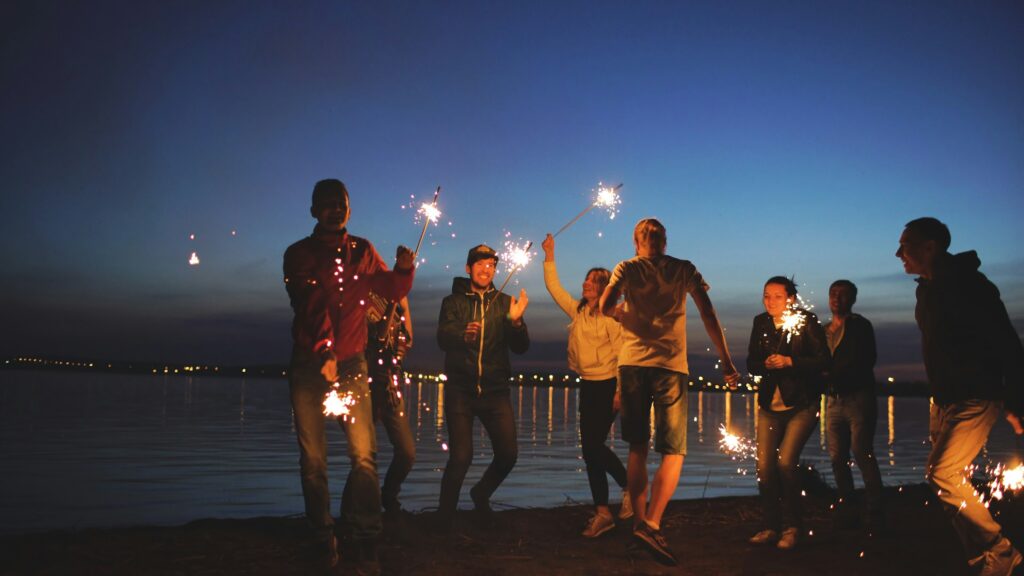 friends with sparklers on the beach
