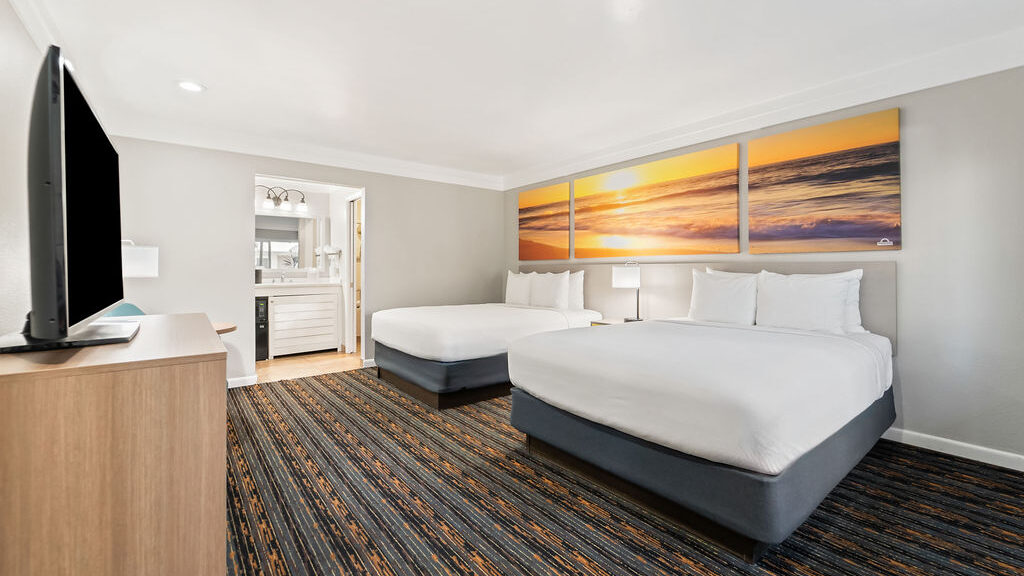 a hotel room with two queen beds and modern furnishings