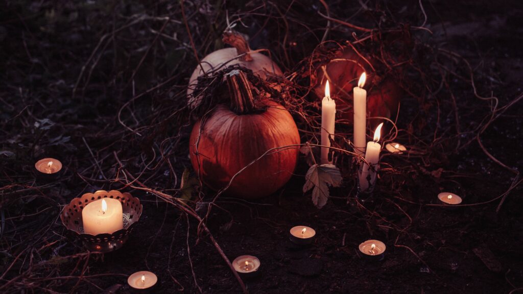 Pumpkins and candles on forest floor